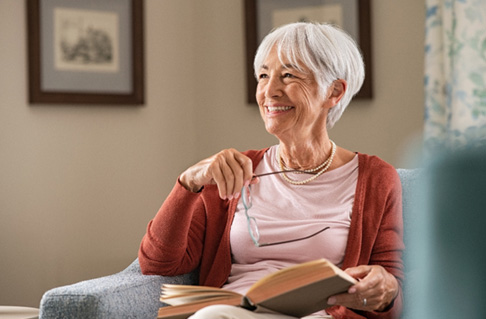 Woman smiling while reading at home