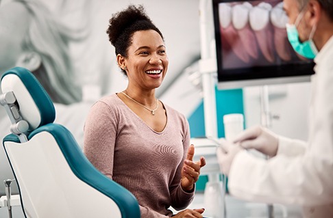 Woman smiling while talking to dentist